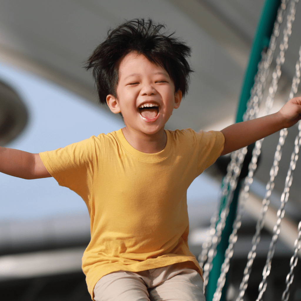 a very happy boy playing in the playground