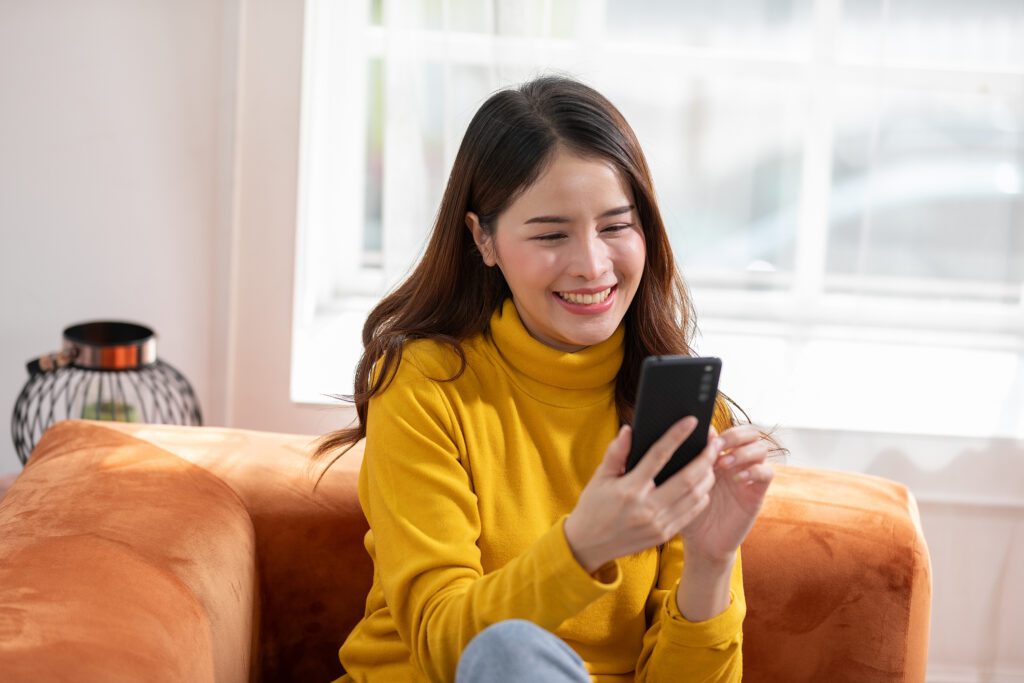 asian woman happy looking at the phone